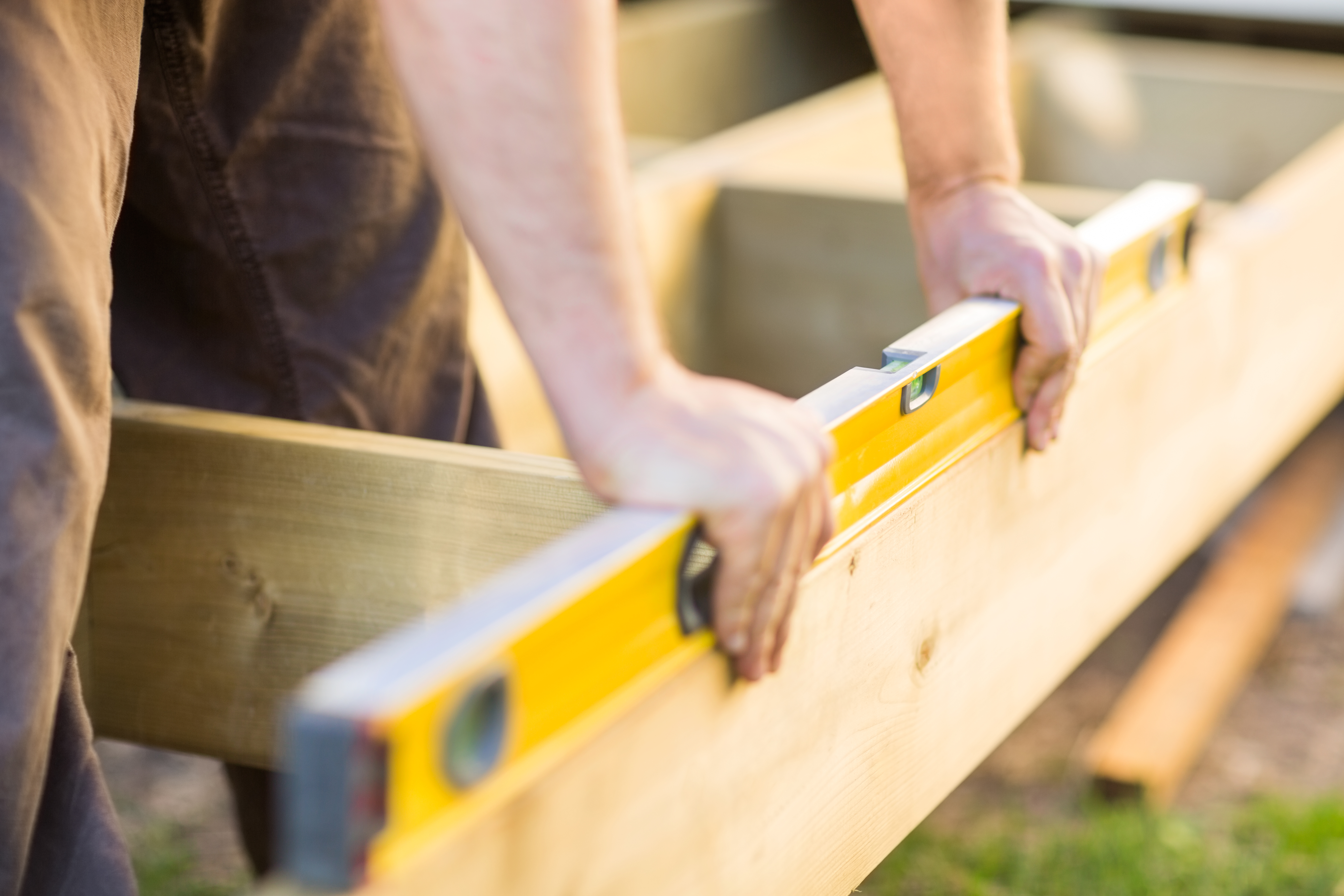 Cropped Image of Carpenter’s Hands Checking Level of Wood